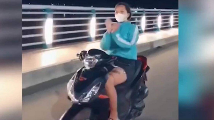 Cô gái đi xe máy không đội mũ bảo hiểm vừa đi vừa múa quạt trên cầu Thạch Bích, Quảng Ngãi - Ảnh 1.