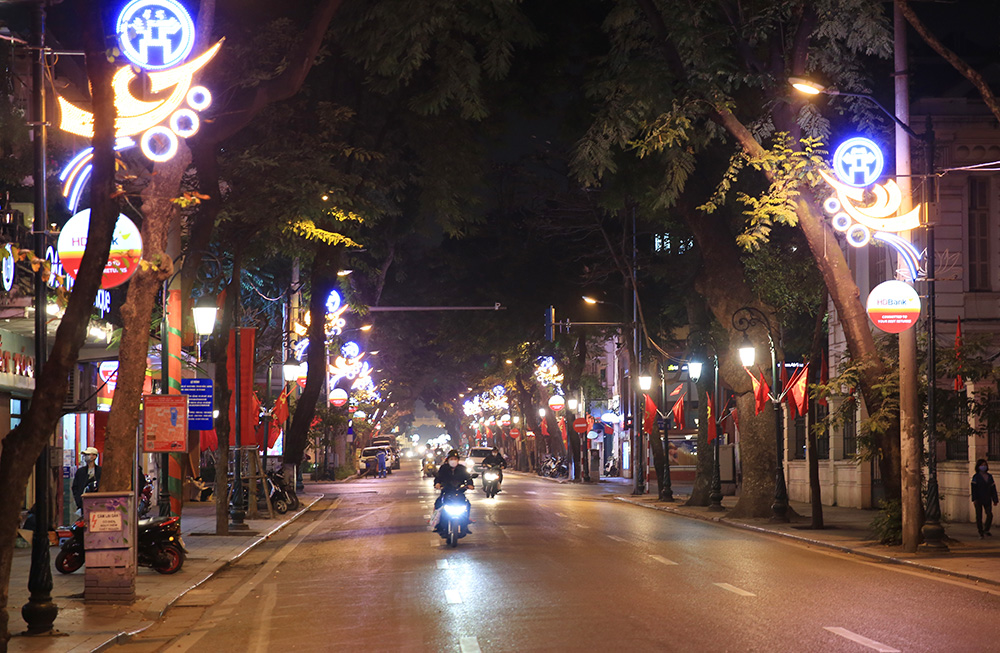 Đêm trước Tết Nguyên đán: Tối nay, trời lạnh và mưa gió, nhưng khắp các nẻo đường vẫn rực rỡ ánh đèn Tết. Hãy xem hình ảnh này để cùng thưởng thức một Khuya Tết trọn vẹn. Chỉ còn vài giờ nữa là Tết đến, hãy chiêm ngưỡng không khí rộn ràng, đặc trưng của mùa Tết Việt cùng bức ảnh này.