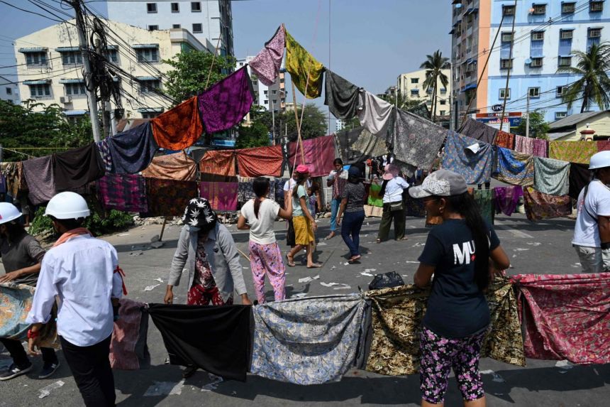 Vì sao người biểu tình Myanmar treo quần áo phụ nữ trên đường phố? - Ảnh 1.