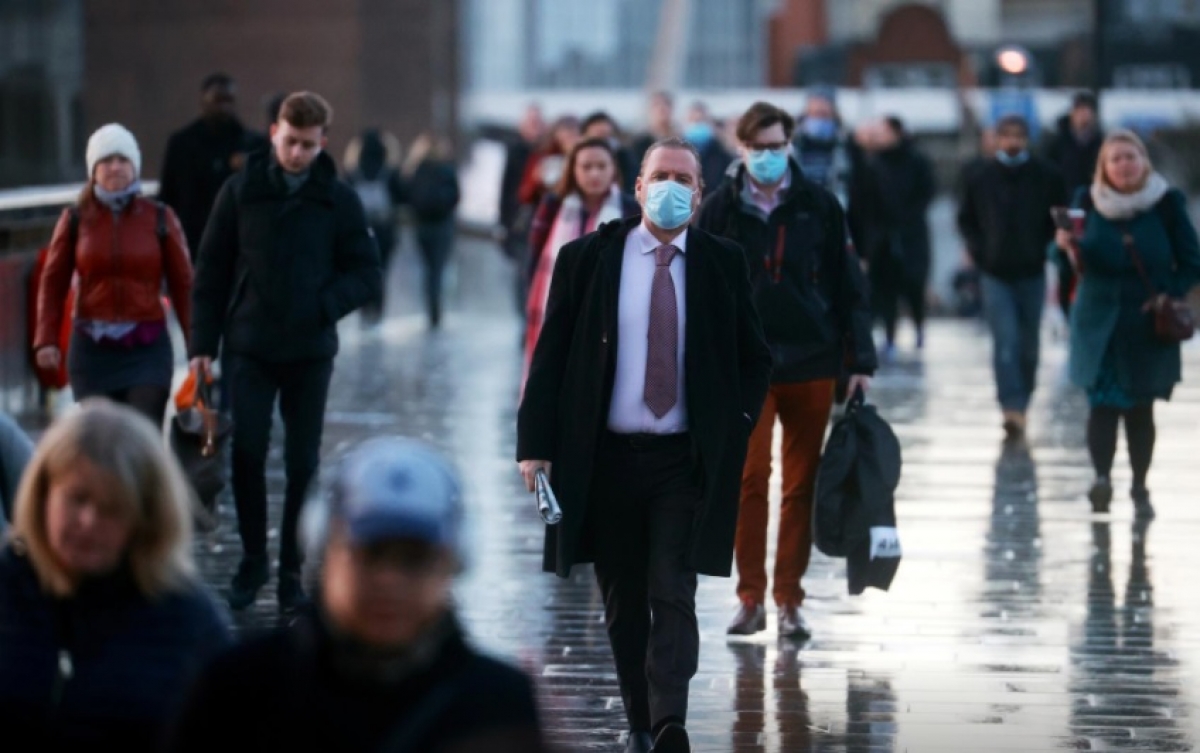Người dân Anh đi bộ qua cầu London ngày 15-12 trong khi virus SARS-CoV-2 vẫn đang lây lan nhanh chóng. Ảnh- Reuters..jpg