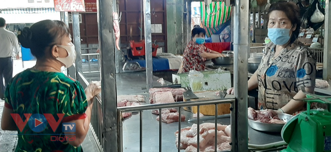 Tiểu thương bán thịt heo ở chợ Bà Chiểu, quận bình Thạnh đang bán hàng cho khách.jpg