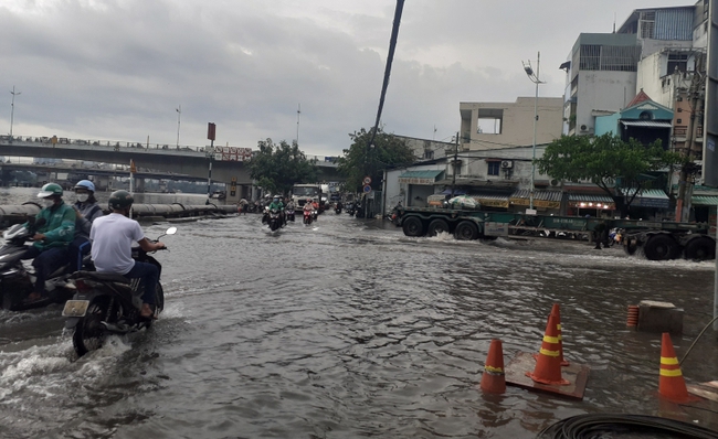 Triều cường dâng cao, người dân ở TP.HCM lội nước về nhà sau giờ tan tầm - Ảnh 3.