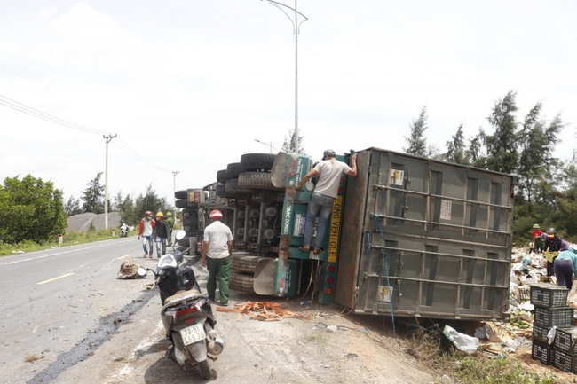 Người dân Quảng Bình giúp tài xế xe tải chở trái cây bị lật nhào trên Quốc lộ - Ảnh 1.