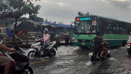 Triều cường dâng cao, người dân ở TP.HCM lội nước về nhà sau giờ tan tầm