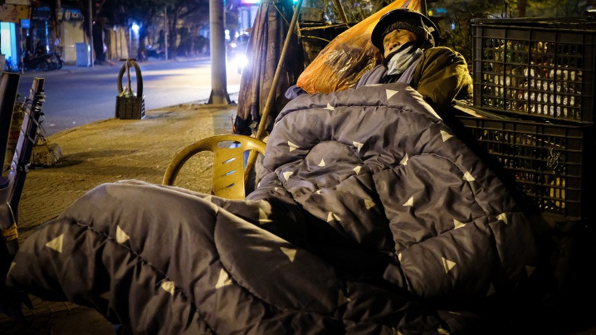 Người vô gia cư co ro đốt lửa, trùm chăn ngủ vỉa hè trong cái rét thấu xương